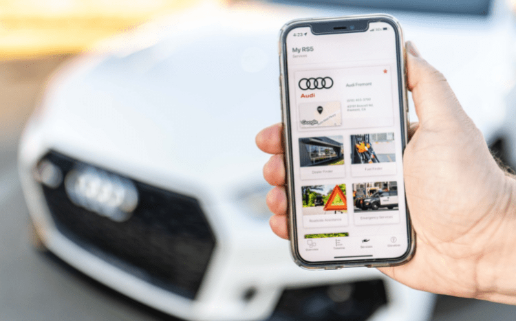 Man holding phone in front of Audi